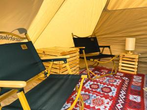ein Zelt mit 2 Stühlen und einem Teppich in einem Zimmer in der Unterkunft Hagiang-holic in Dồng Văn