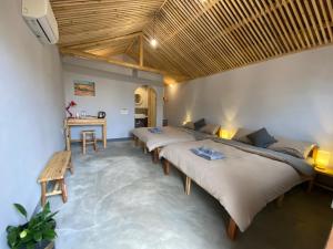 a room with three beds and a desk in it at Hagiang-holic in Dồng Văn
