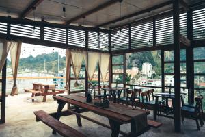 a restaurant with wooden tables and chairs and windows at Hagiang-holic in Dồng Văn