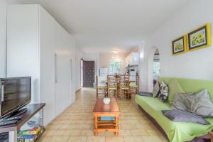 a living room with a green couch and a television at Spacious Ground Floor Apartment in Denia