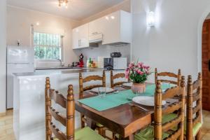 a kitchen and dining room with a wooden table and chairs at Spacious Ground Floor Apartment in Denia