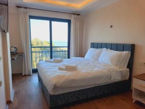 una camera da letto con un letto con vista sull'oceano di NORTH WIND HOTELS - Karaburun a Karaburun Altre 75 foto