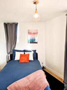 um quarto com uma cama azul e uma almofada laranja em Le Vernonnais Chic, Gare Wifi Parking Giverny em Vernon