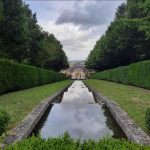 um canal de água num jardim com uma casa ao fundo em Le Vernonnais Chic, Gare Wifi Parking Giverny em Vernon