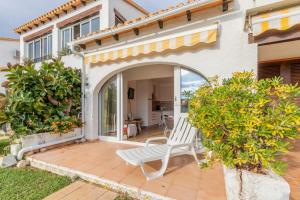 Ein weißer Stuhl steht auf einer Terrasse vor einem Haus. in der Unterkunft Retirosol Bungalow in Denia