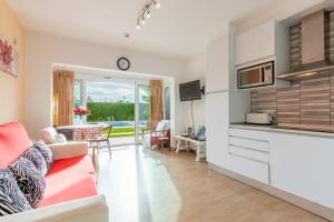 eine Küche und ein Wohnzimmer mit einer Couch und einem Tisch in der Unterkunft Retirosol Bungalow in Denia