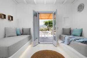 a living room with a door open to a patio at Xerolithos Natural Living in Naxos Chora