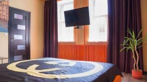 1 dormitorio con 1 cama y TV de pantalla plana en Doba in ua Starokazatskay Apartments, en Dnipro