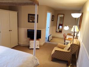 a bedroom with a bed and a desk and a television at The Sibson Inn Hotel in Water Newton