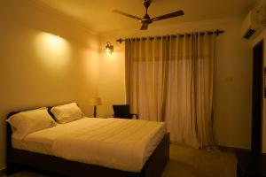 um quarto com uma cama e uma ventoinha de tecto em Martins Crest em Patnem