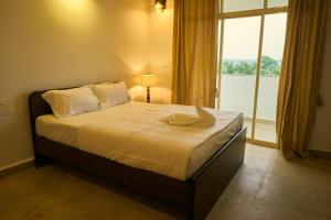 a bedroom with a bed with a large window at Martins Crest in Patnem