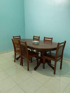 a wooden table with four wooden chairs around it at illiy's homestay in Tangga Batu