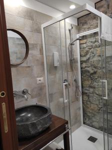 ein Bad mit einem Waschbecken und einer Glasdusche in der Unterkunft TIK TAK in Verbicaro
