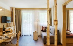 een woonkamer met een bed en een eetkamer bij Alpin Stile Hotel in Laion