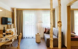 sala de estar con cama y comedor en Alpin Stile Hotel, en Laion