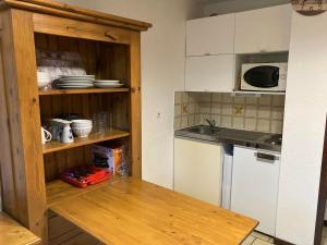 a kitchen with a counter and a sink and a refrigerator at studio Les Glieres in Bourg-Saint-Maurice