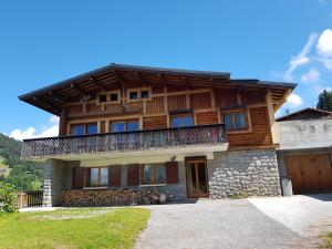 a wooden house with a balcony on top of it at B&B La Seigneurie in Les Gets