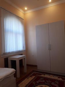 a bedroom with a white cabinet and a table at GUESTO HOSTEL in Tashkent