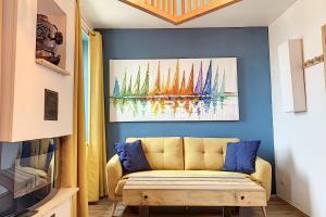 a living room with a couch and a painting on the wall at AS 50 - Les bateaux au bord de l'eau in Ault
