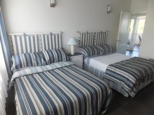 2 camas en una habitación de hotel con sábanas a rayas en Superb Split Level Waterside Apt, Marigot Bay, St Lucia WI, en Castries 37 fotos más