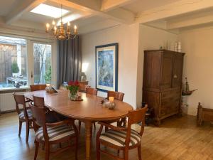 een eetkamer met een houten tafel en stoelen bij De Thuiskamer in Grou als B&B of Vakantiehuis in Grou