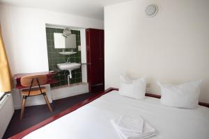 - une chambre avec un lit, un lavabo et un miroir dans l'établissement Hotel Internationaal, à Amsterdam