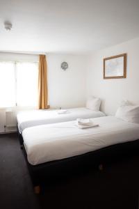- deux lits assis l'un à côté de l'autre dans une pièce dans l'établissement Hotel Internationaal, à Amsterdam