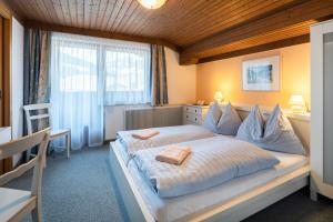 a bedroom with a large bed with two towels on it at Pension Mühlhof in Neukirchen am Großvenediger