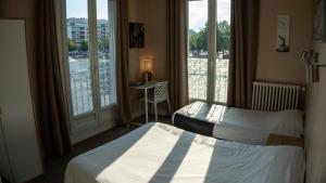 a hotel room with two beds and a window at Hotel De l'Univers in Caen +81 photos