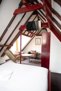 una stanza con un letto, un divano e una TV di Hotel Internationaal ad Amsterdam