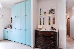 a dressing room with blue cabinets and a wooden dresser at CASA PINALDO in Ginosa Marina