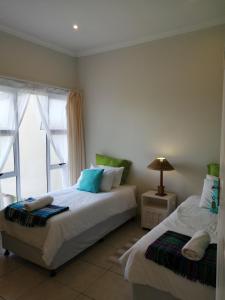 a bedroom with two beds and a window at Serendipity Country House in Amanzimtoti