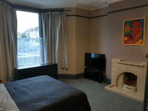 a bedroom with a bed and a fireplace and a television at Sunnyside Lodge in Weston-super-Mare