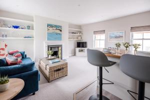 a living room with a blue couch and a table at Pebble View in Aldeburgh