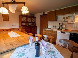 a kitchen with a wooden table with a bottle of wine at Charming Alp Cottage in the Mountains of Salzburg in Bicheln