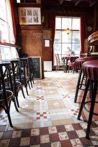 een restaurant met tafels en stoelen en een geruite vloer bij Hotel Internationaal in Amsterdam