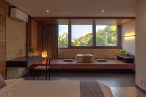 a bedroom with a bed and a desk and a window at Yangshuo Hillside Homestay in Yangshuo