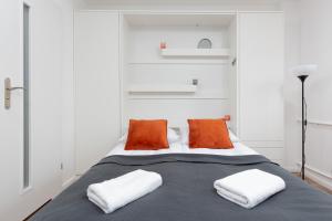 1 dormitorio con 1 cama con almohadas de color naranja y blanco en Studio Apartment Ochota Siemieńskiego by Renters, en Varsovia
