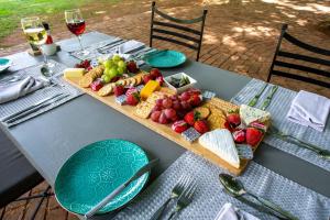 a table with a tray of fruit and cheese on it at Whispering Pines Country Estate in Magaliesburg