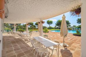 Un patio con mesas y sillas y una sombrilla. en Apartment Miraflores, en Mijas Costa