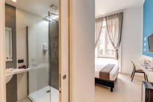 a bathroom with a shower and a bed and a sink at Manin Suites LT in Rome