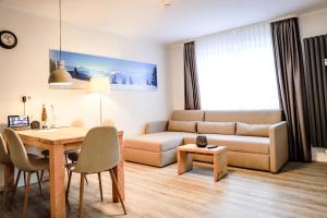 uma sala de estar com um sofá e uma mesa em Smart Resorts Haus Azur Ferienwohnung 804 em Winterberg