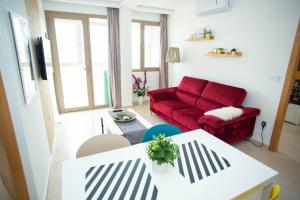 een woonkamer met een rode bank en een tafel bij My Cosy Place Rabat - Appartements à 50m de la gare Agdal TGV in Rabat