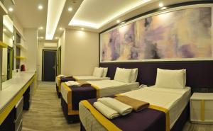 eine Reihe von Betten in einem Hotelzimmer in der Unterkunft Campus Hill Hotel in Alanya