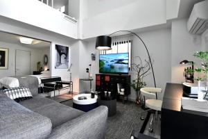 a living room with a couch and a tv at LANG Hotel Ginza 1LDK in Tokyo