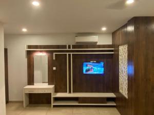 a bathroom with a tv and a vanity with a mirror at THE PORCH INN in Wayanad