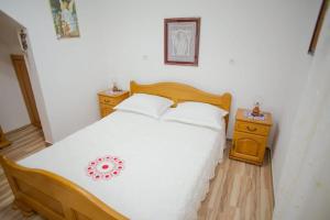 1 dormitorio con cama blanca y mesita de noche en Apartmani Bepina, en Metajna