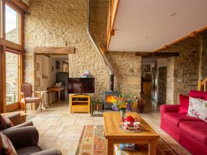 a living room with a red couch and a fireplace at Tom's Barn in Cheltenham