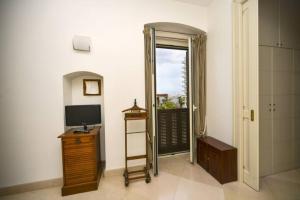 een kamer met een televisie en een deur naar een balkon bij Scesa San Michele in Bari
