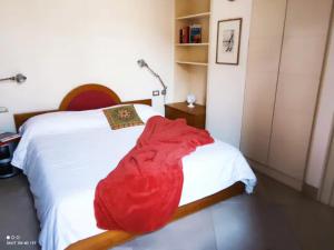 Scesa San Michele في باري: غرفة نوم مع سرير مع بطانية حمراء عليه